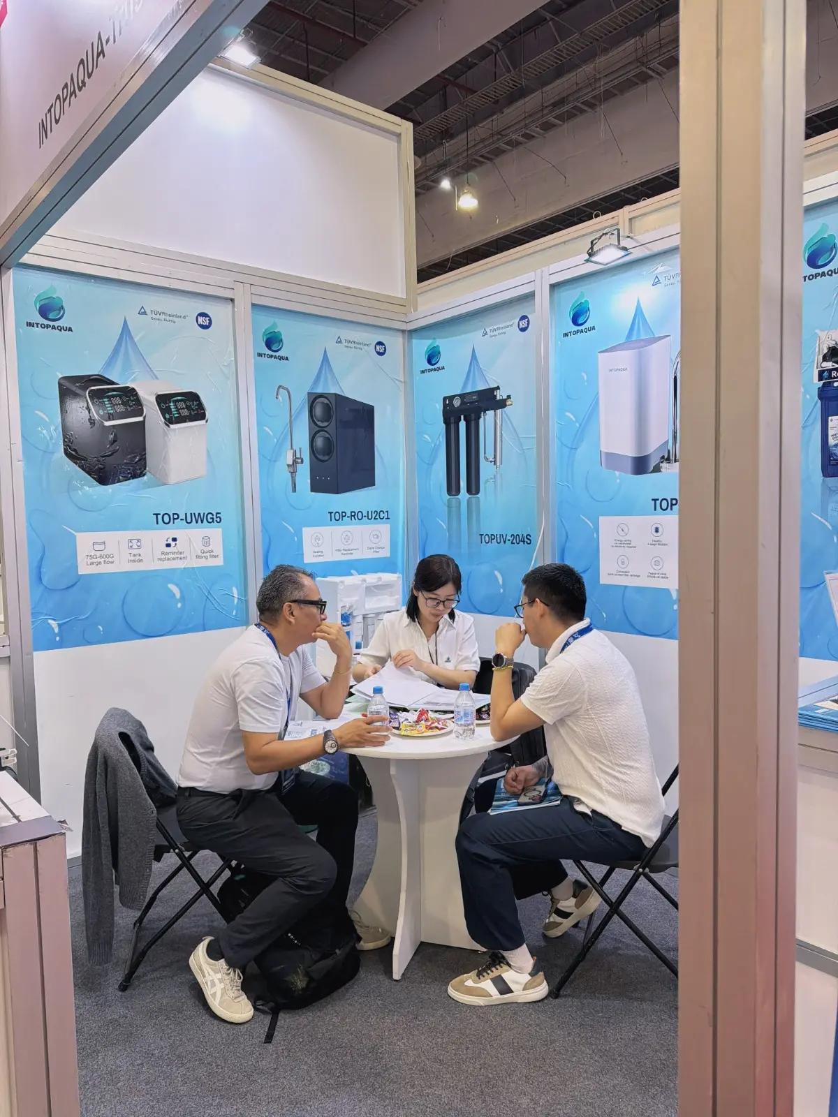 Visitors discussing water purification products at the INTOP booth